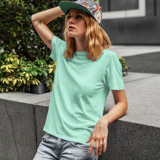 Woman wearing a light green t-shirt and colorful cap outdoors