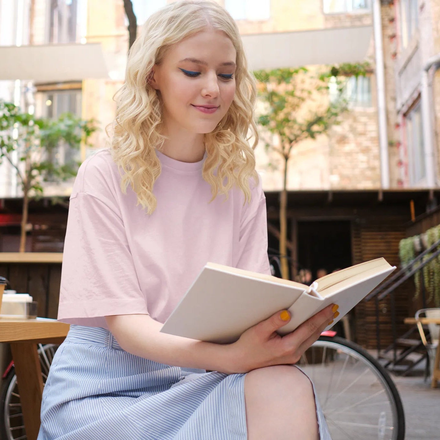 Woman reading a book in an outdoor cafe setting
