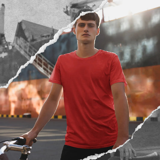 Person in a red shirt holding a bicycle with a ship and containers in the background