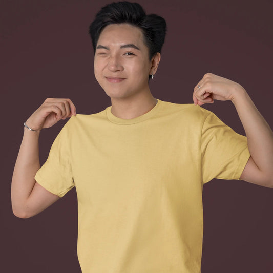 Person wearing a yellow t-shirt on a dark background