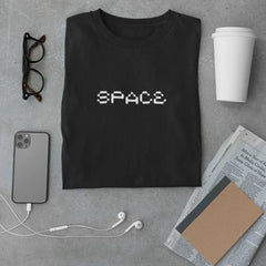 Black t-shirt with 'SPACE' print on a gray surface with phone, glasses, and coffee.