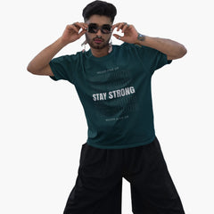 Man wearing a green t-shirt with motivational text on a white background