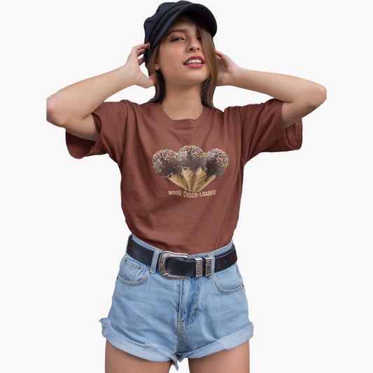 Woman wearing a brown t-shirt with a graphic design and denim shorts on a white background