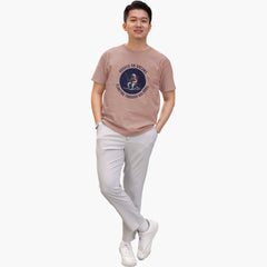Man wearing a brown t-shirt with a graphic design on a white background