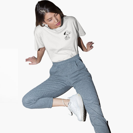 Person wearing a white t-shirt with a graphic and blue pants on a white background