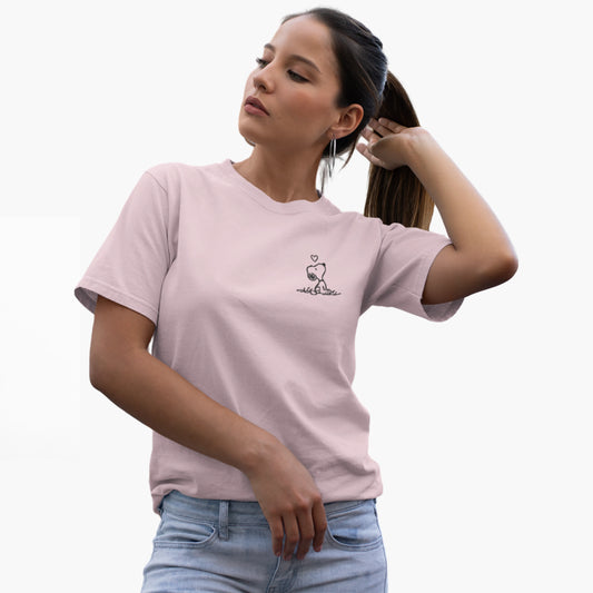 Woman wearing a light pink t-shirt with a small graphic on a white background