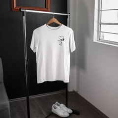 White t-shirt with a small graphic on a hanger in a room with a window.