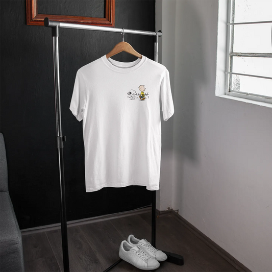 White t-shirt with a small design on a hanger in a room with a window.