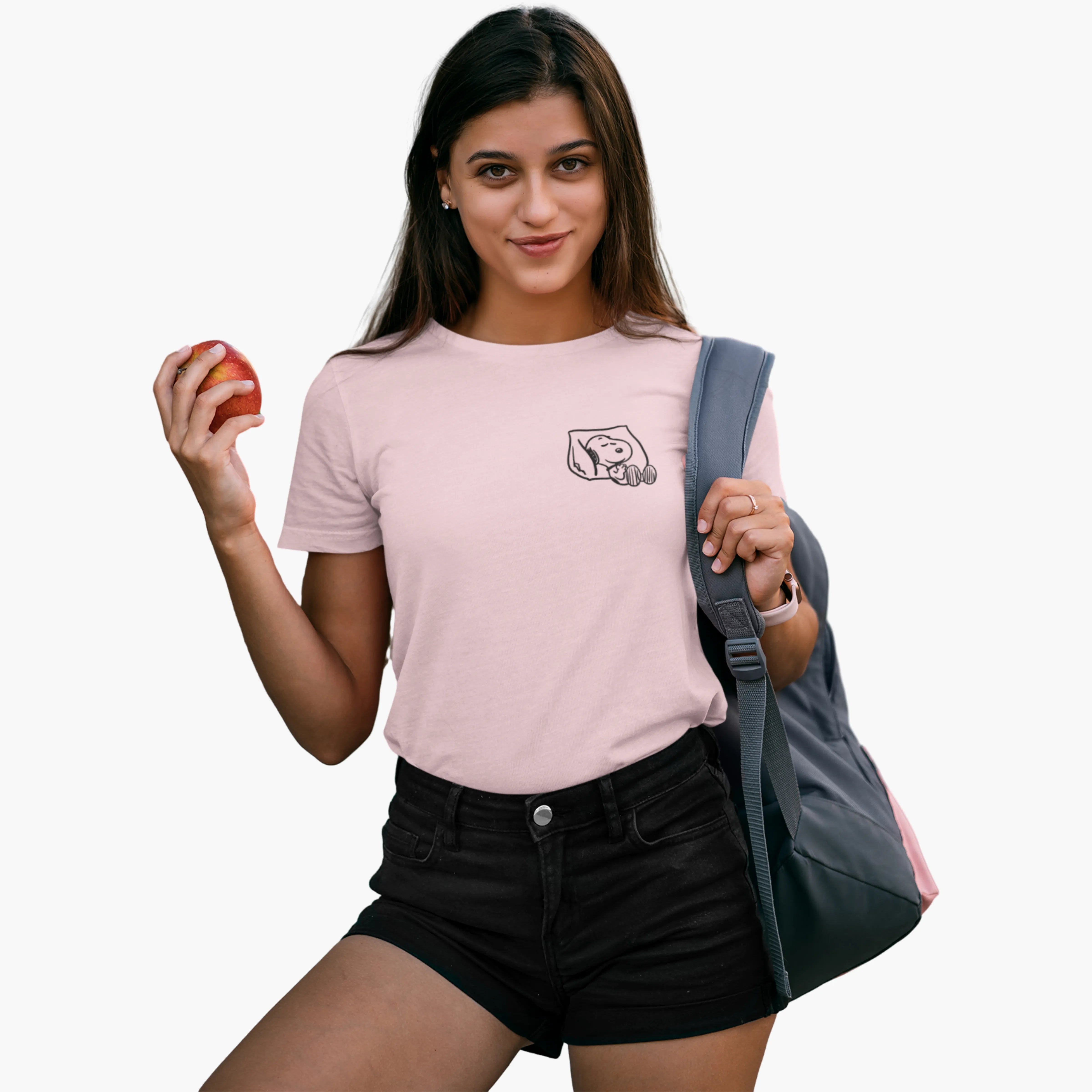 Woman wearing a pink t-shirt with a logo, holding an apple and a gray bag on a white background