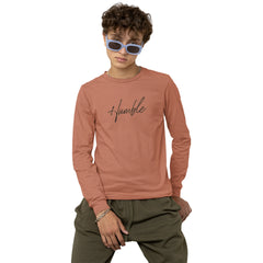 Person wearing a pink long-sleeve shirt with 'humble' text and green pants on a white background