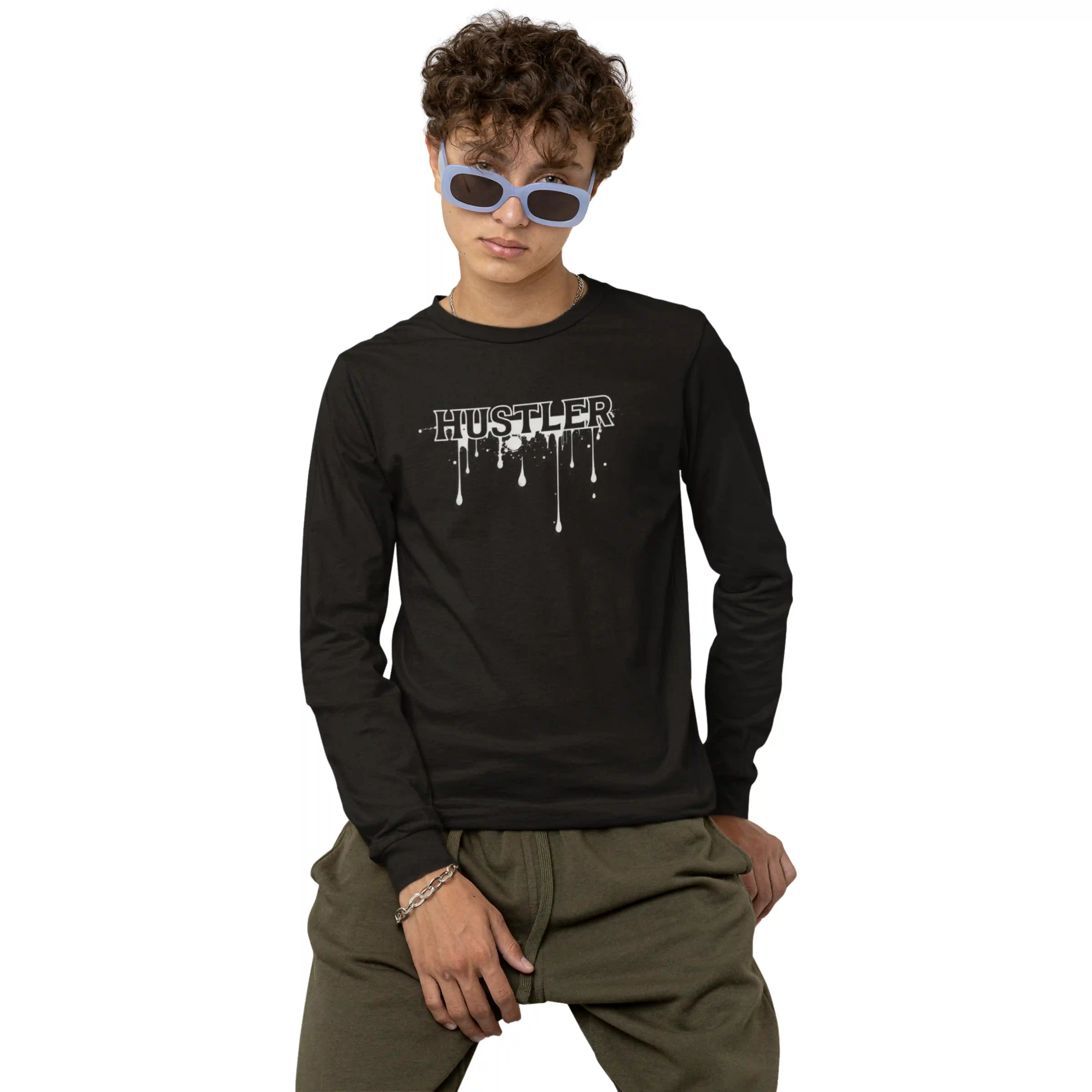 Child wearing a black long-sleeve shirt with 'Hustler' print and green pants on a white background