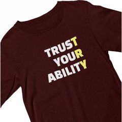 Maroon t-shirt with 'Trust Your Ability' text in white and yellow on a white background