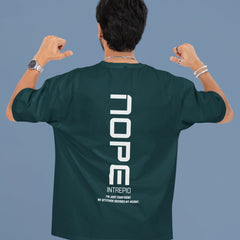 Person wearing a green t-shirt with 'NOPE' printed on the back against a blue background