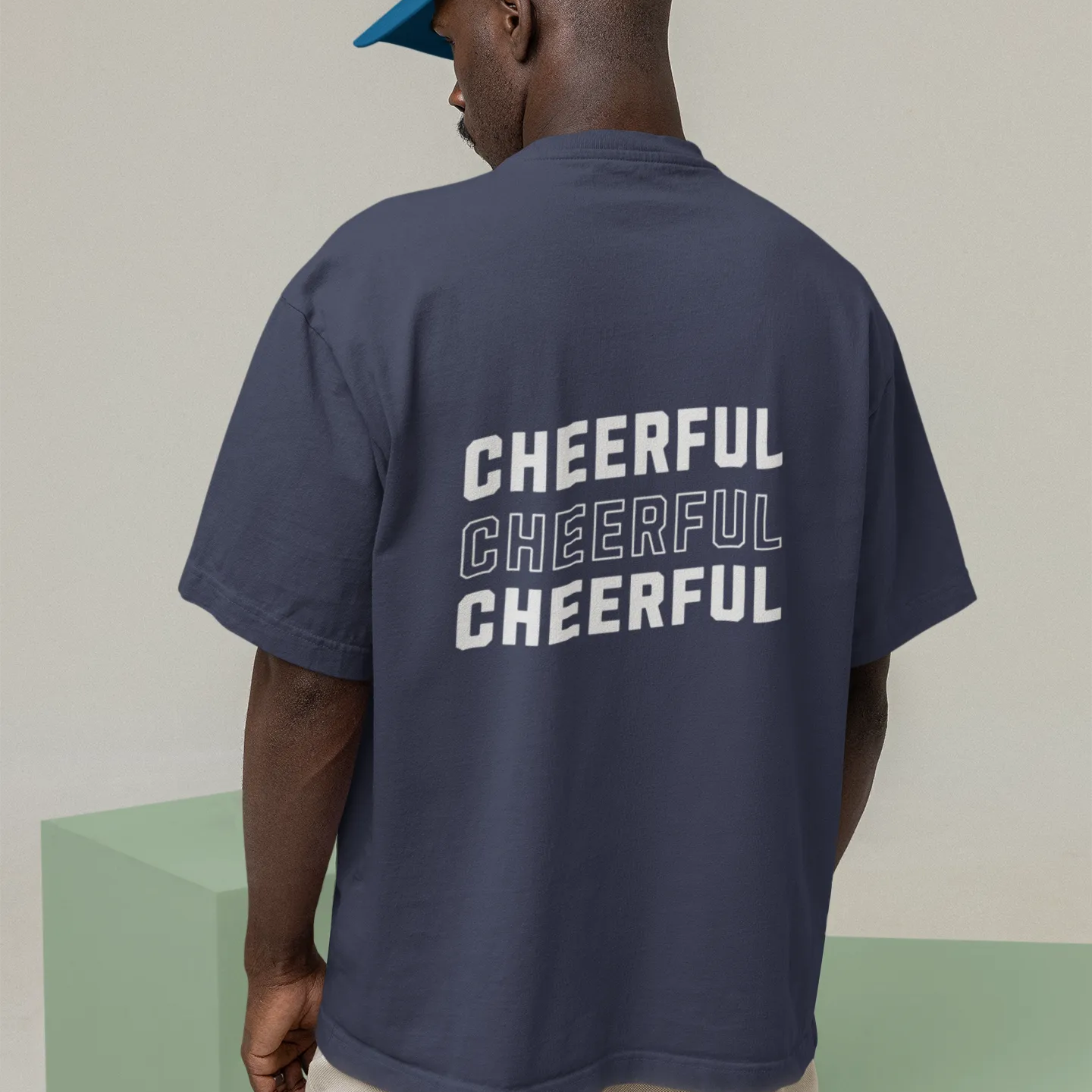 Person wearing a navy t-shirt with 'CHEERFUL' text on the back, standing against a plain background.