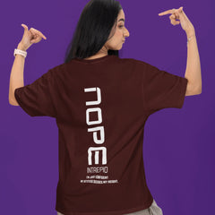Person wearing a brown t-shirt with 'NOPE' printed on the back against a purple background