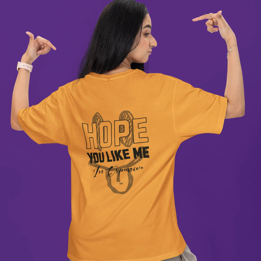 Person wearing a mustard yellow t-shirt with text on the back against a purple background