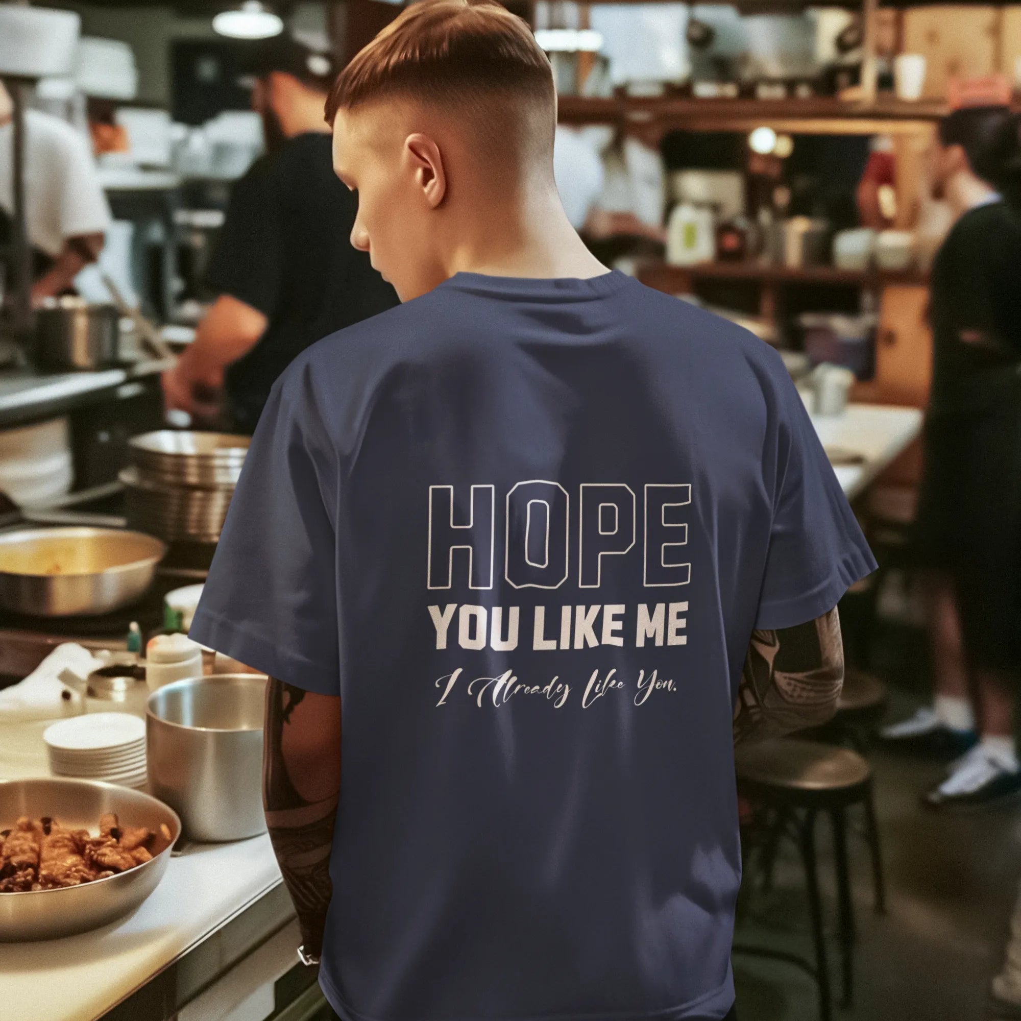 Person wearing a blue t-shirt with text in a kitchen setting