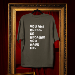 Gray t-shirt with motivational text on a red curtain background
