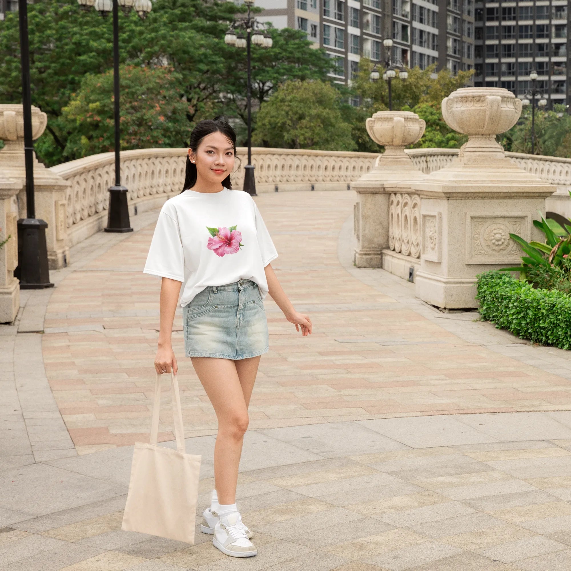 Woman walking on a sidewalk with a scenic background of trees and buildings.