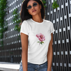 Woman wearing a white t-shirt with a pink flower design in an urban setting.
