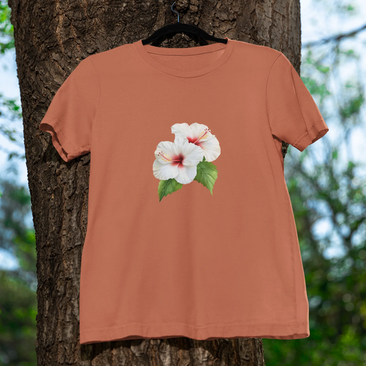 Coral t-shirt with a floral design hanging on a tree