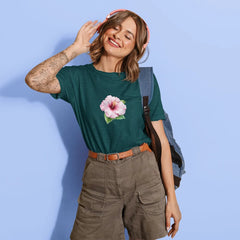 Woman wearing a green t-shirt with a pink flower design against a light blue background