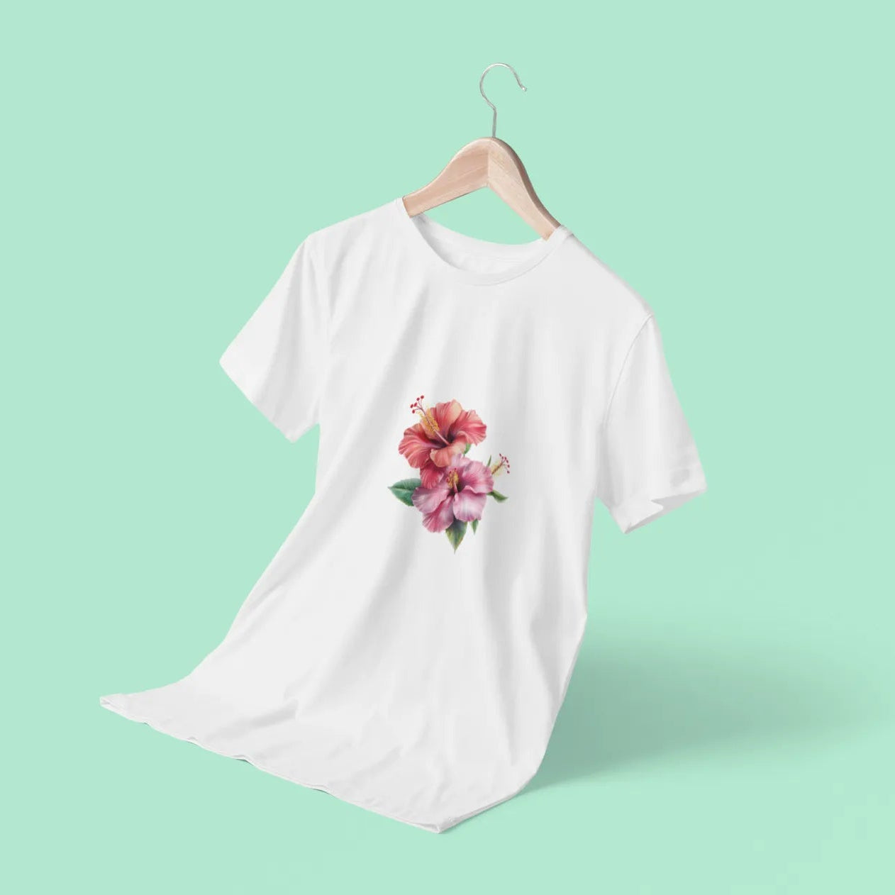 White t-shirt with a floral design on a hanger against a light green background