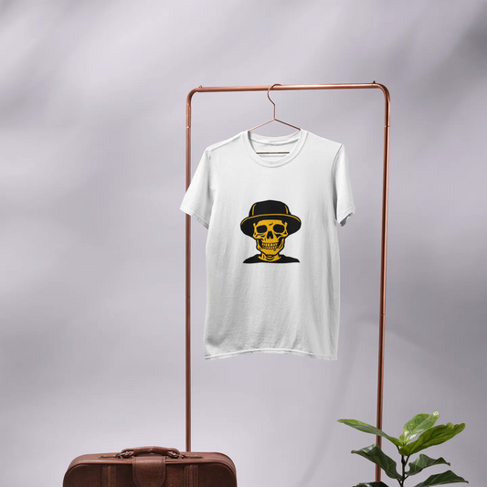 White t-shirt with a graphic design on a rack, next to a brown suitcase and potted plant.