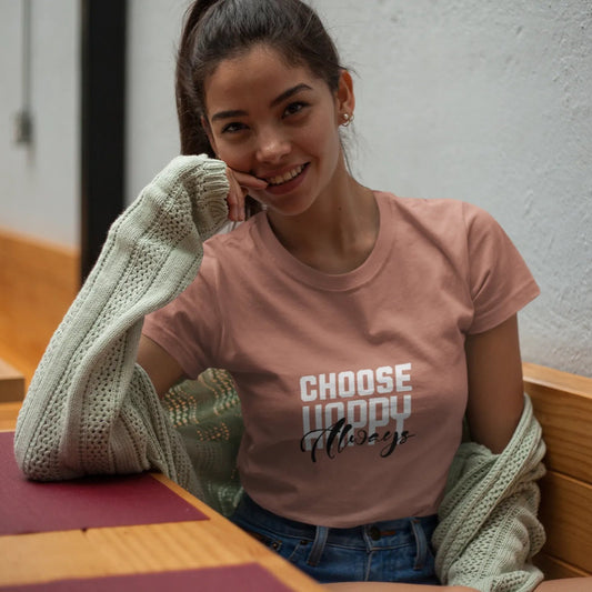 Woman wearing a pink t-shirt with text, sitting in a casual setting.