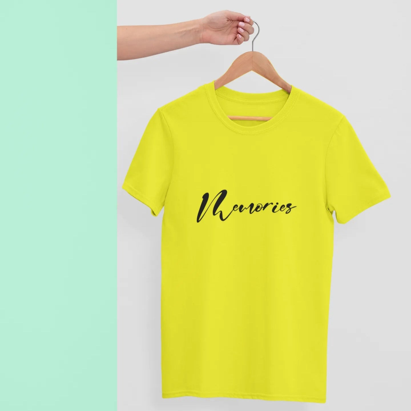 Yellow t-shirt with 'Memories' text on a hanger against a light green background