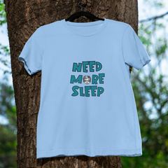 Light blue t-shirt with 'NEED MORE SLEEP' text hanging on a tree