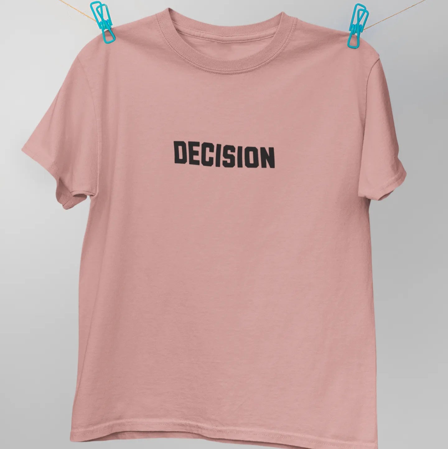 Pink t-shirt with 'DECISION' text on a white background