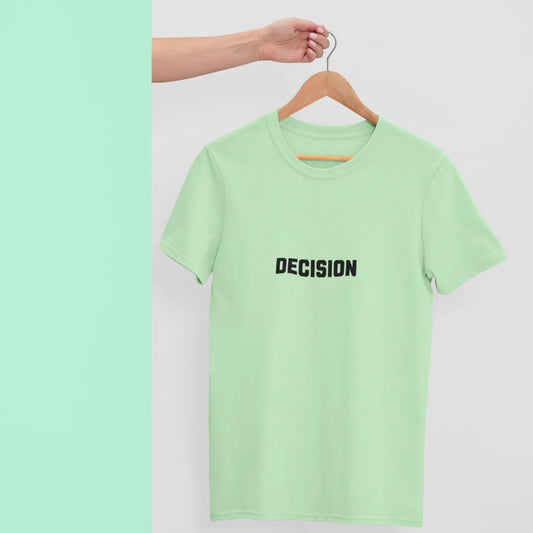 Light green t-shirt with 'DECISION' text on a hanger against a light gray background