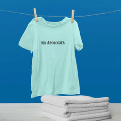 Light blue t-shirt with 'NO APOLOGIES' text hanging on a clothesline against a blue background.