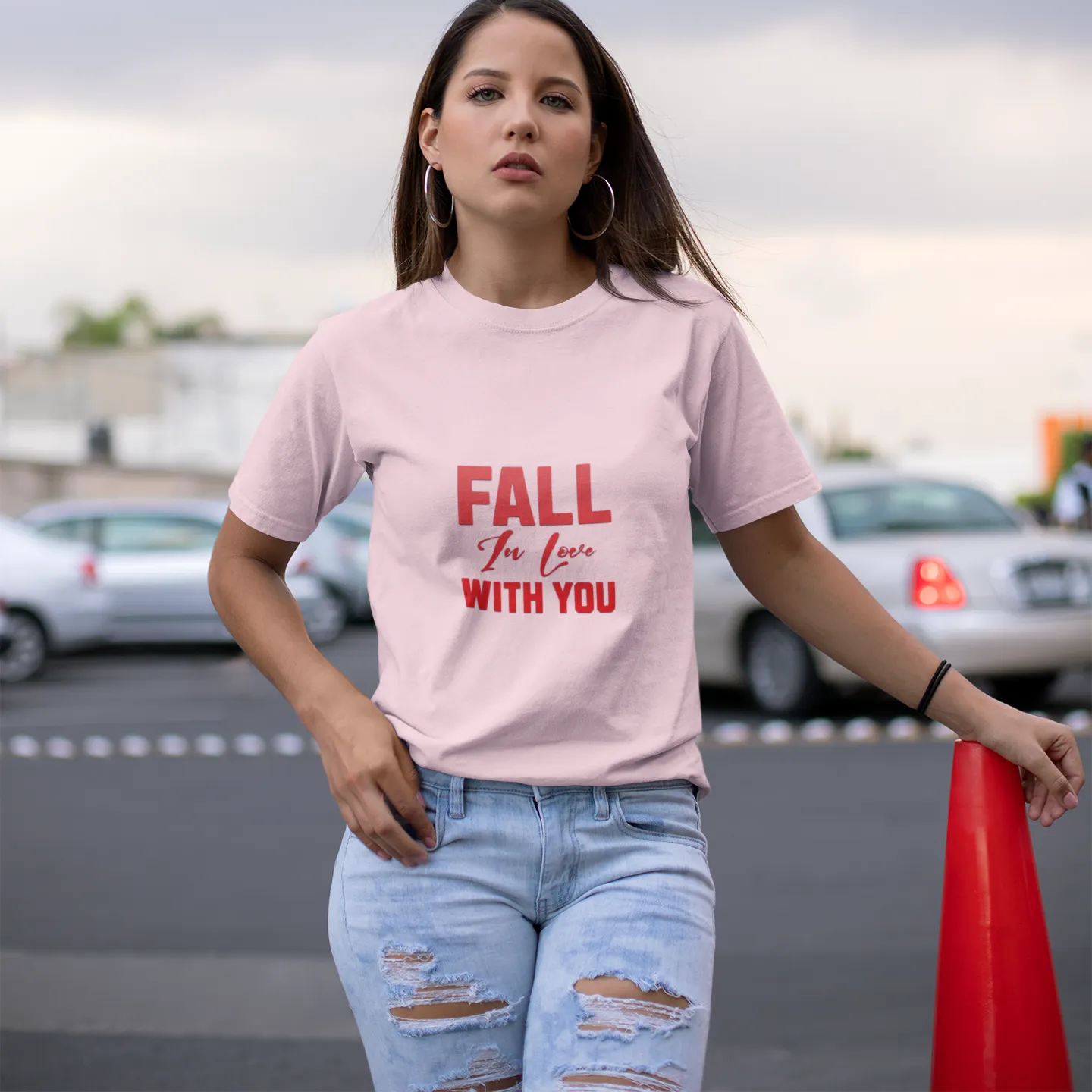 Woman wearing a pink t-shirt with text in an outdoor setting