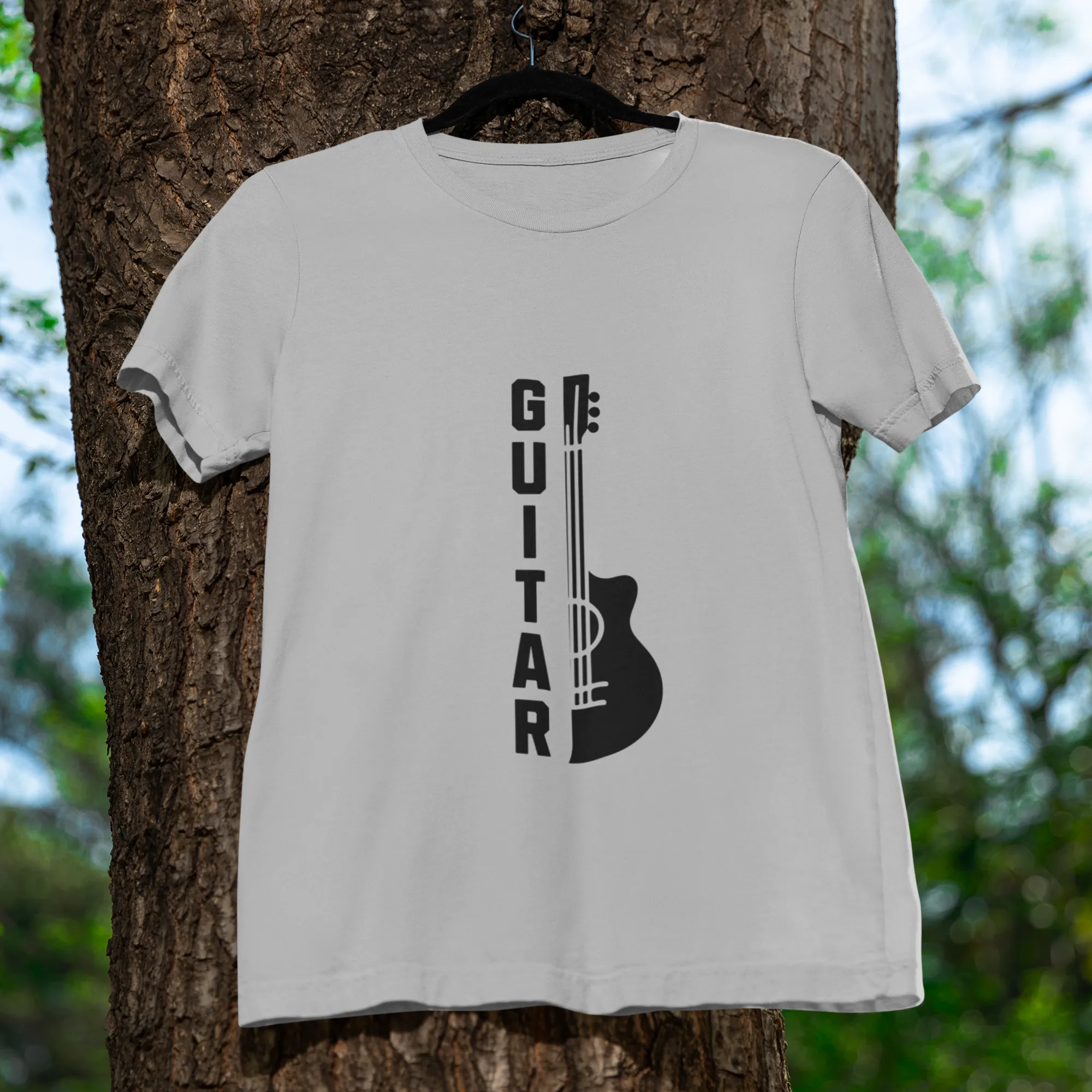 White t-shirt with guitar graphic and 'GUITAR' text on a tree trunk