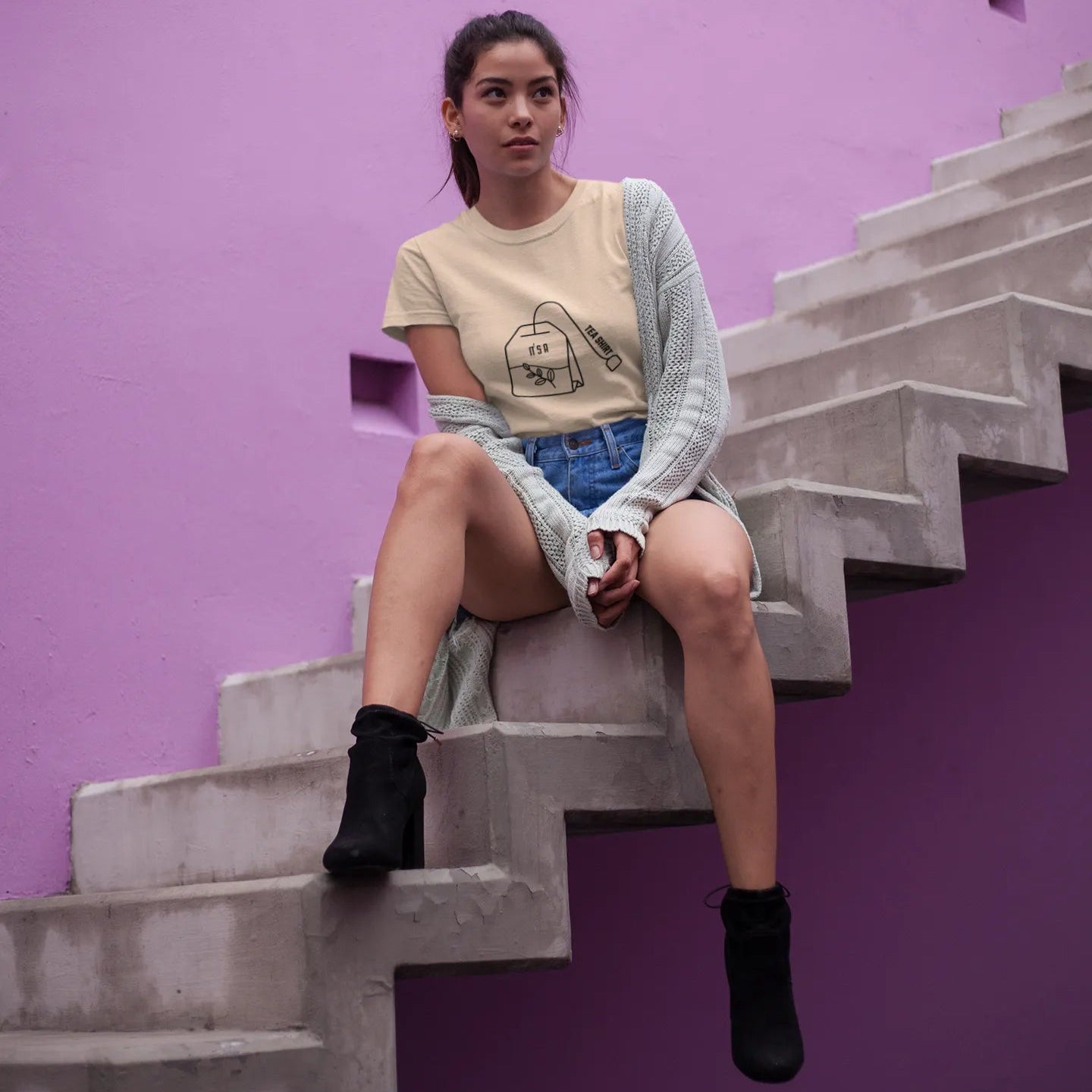 Woman sitting on a staircase against a purple wall
