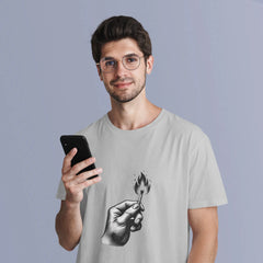 Man wearing a t-shirt with a graphic design of a hand holding a match and a phone, against a plain background.