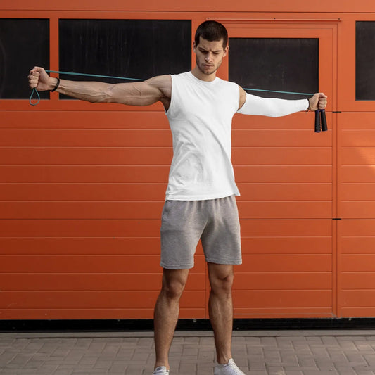Man using resistance bands against an orange wall