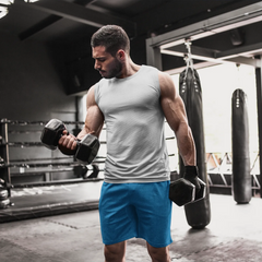 Man exercising with dumbbells in a gym setting