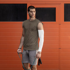 Man holding a jump rope in front of an orange wall