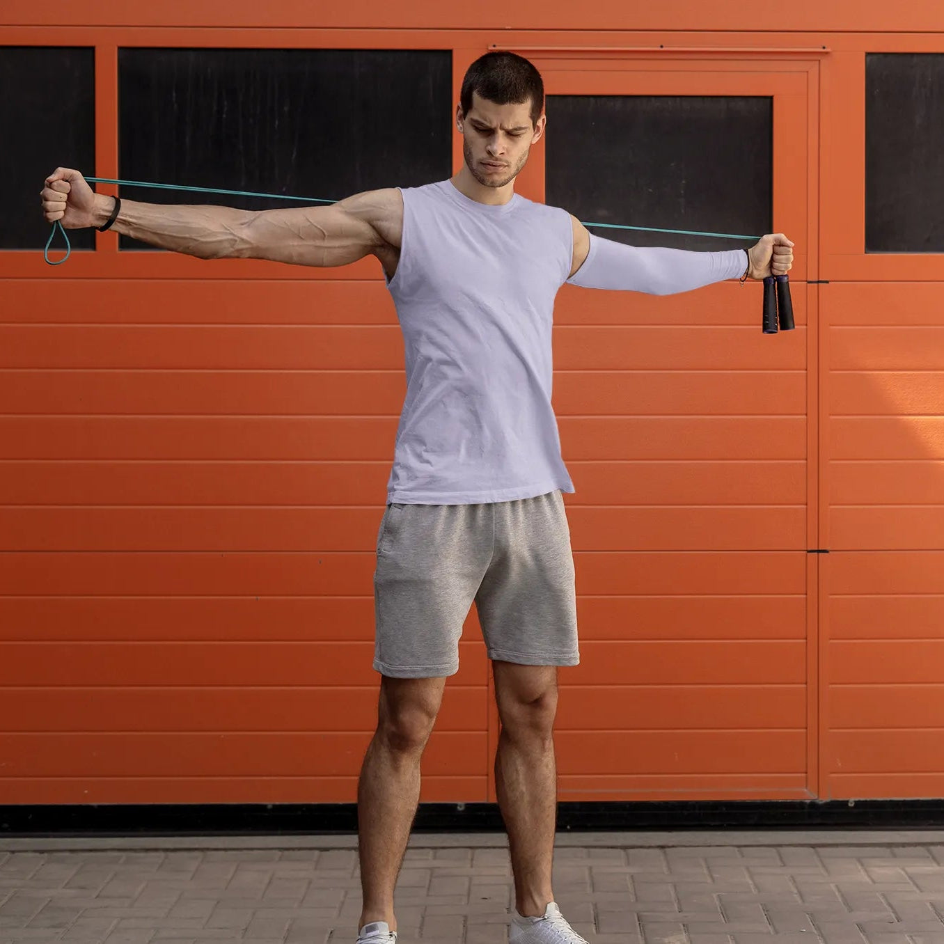 Man using resistance bands in front of an orange garage door
