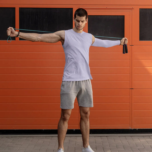 Man using resistance bands in front of an orange garage door