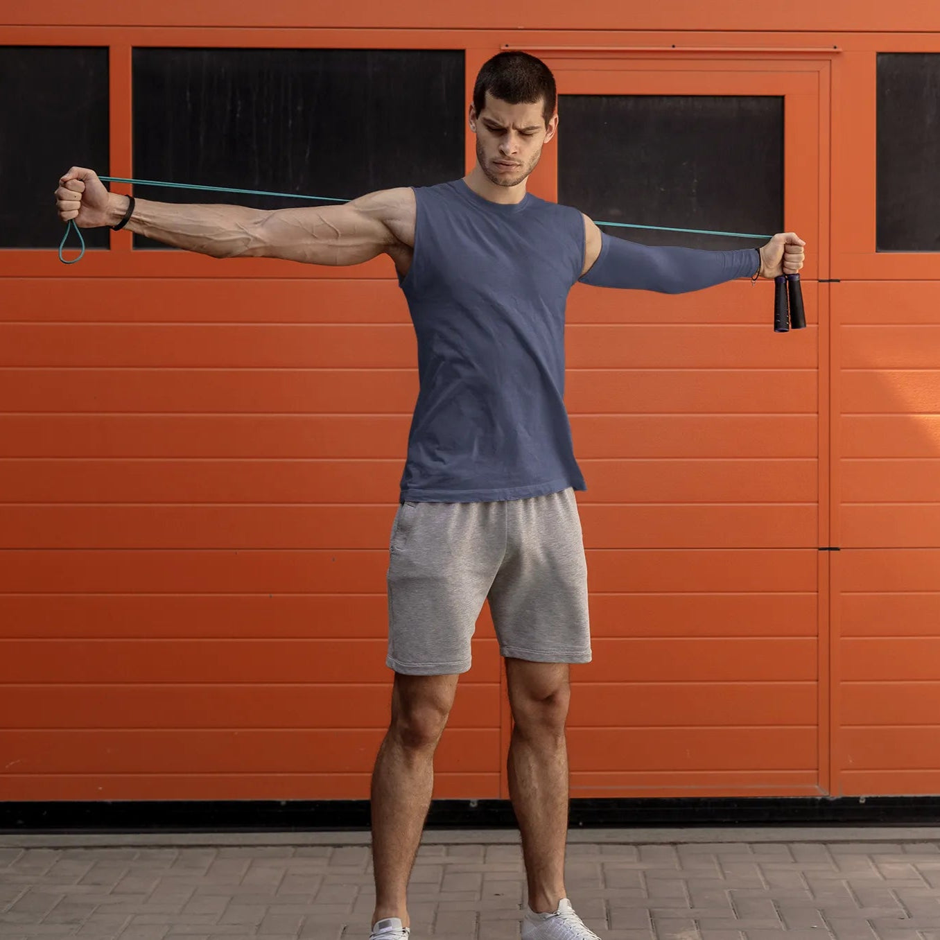 Man exercising with resistance bands in front of an orange wall