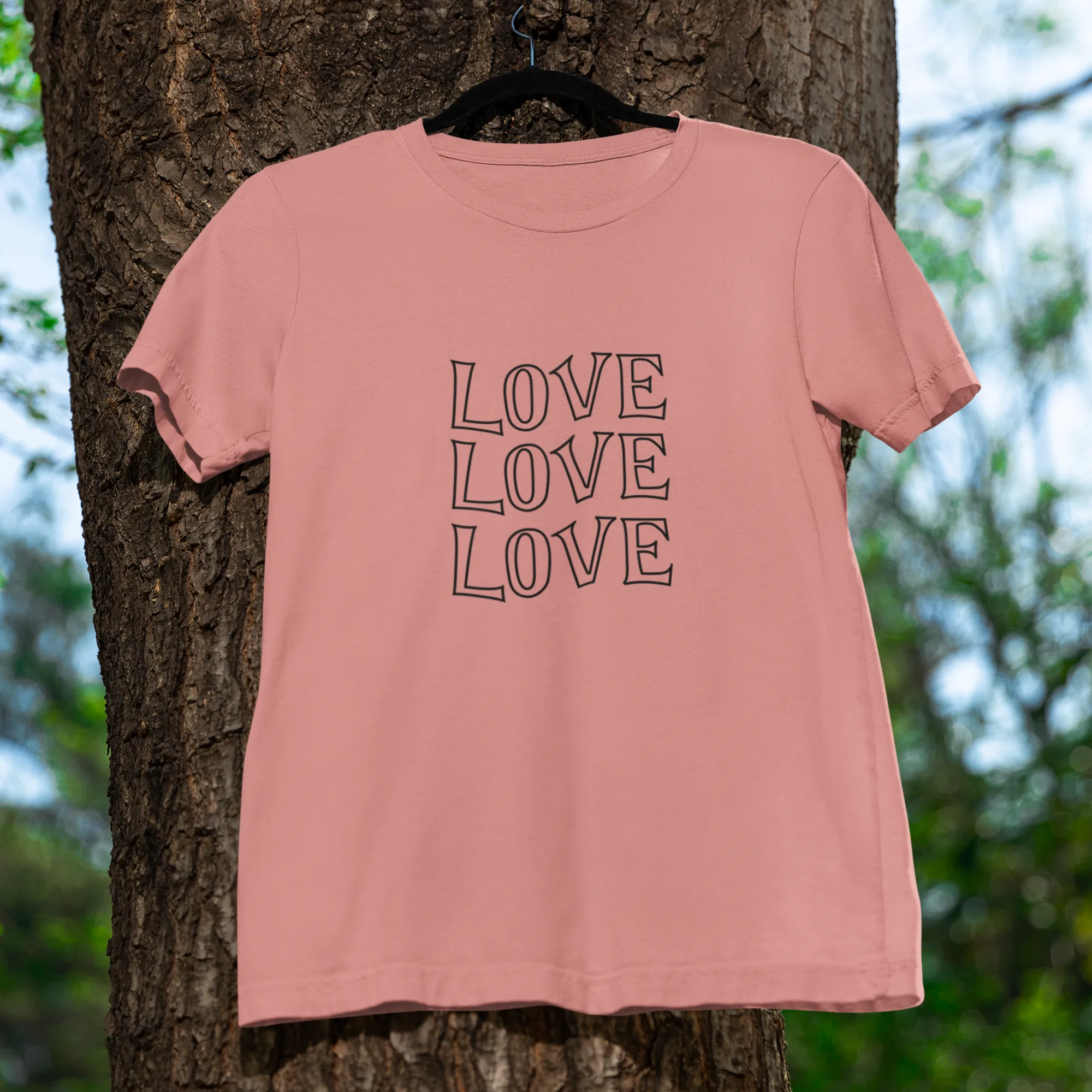 Pink t-shirt with 'LOVE LOVELOVE' text hanging on a tree