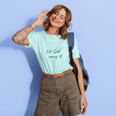 Woman wearing a light blue t-shirt with text, standing against a light blue background