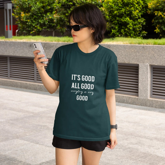 Woman wearing a green t-shirt with text, standing outdoors.
