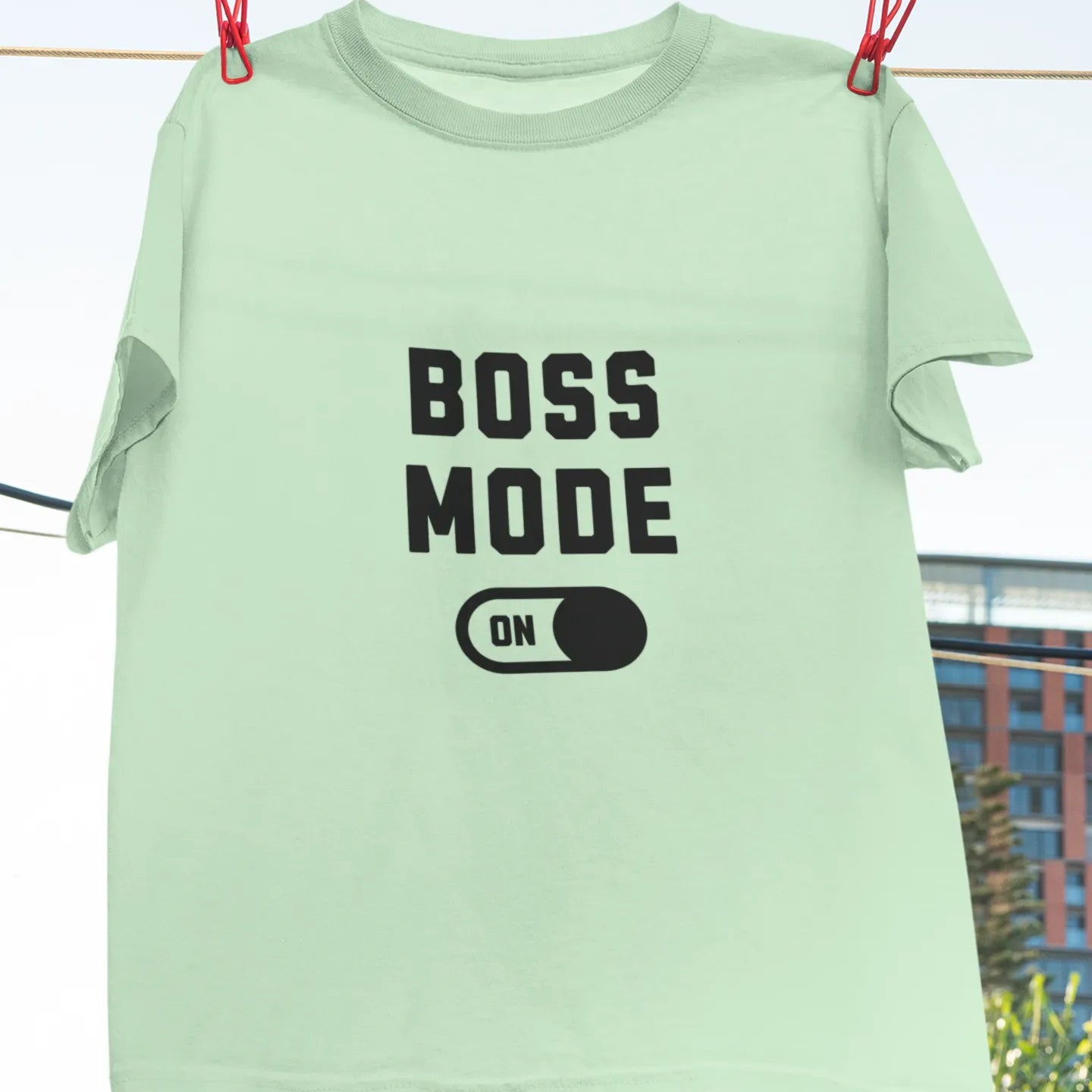 Mint green t-shirt with 'BOSS MODE ON' text on a clothesline.