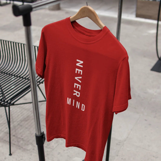 Red t-shirt with 'NEVER MIND' text on a hanger against a blurred indoor background