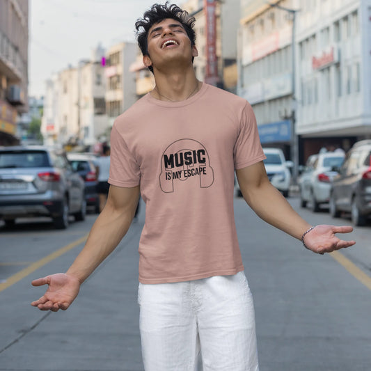 Person wearing a pink t-shirt with 'Music is my escape' text on a city street.